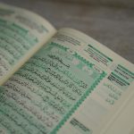 Open Quran displaying Arabic script, close-up view, suitable for religious and educational themes.
